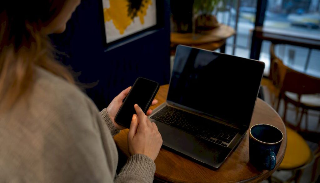 Hands holding smartphone with dark screen