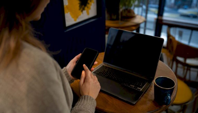 Hands holding smartphone with dark screen