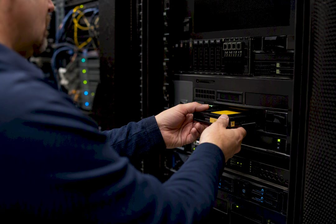 Technician swapping backup tape in server room