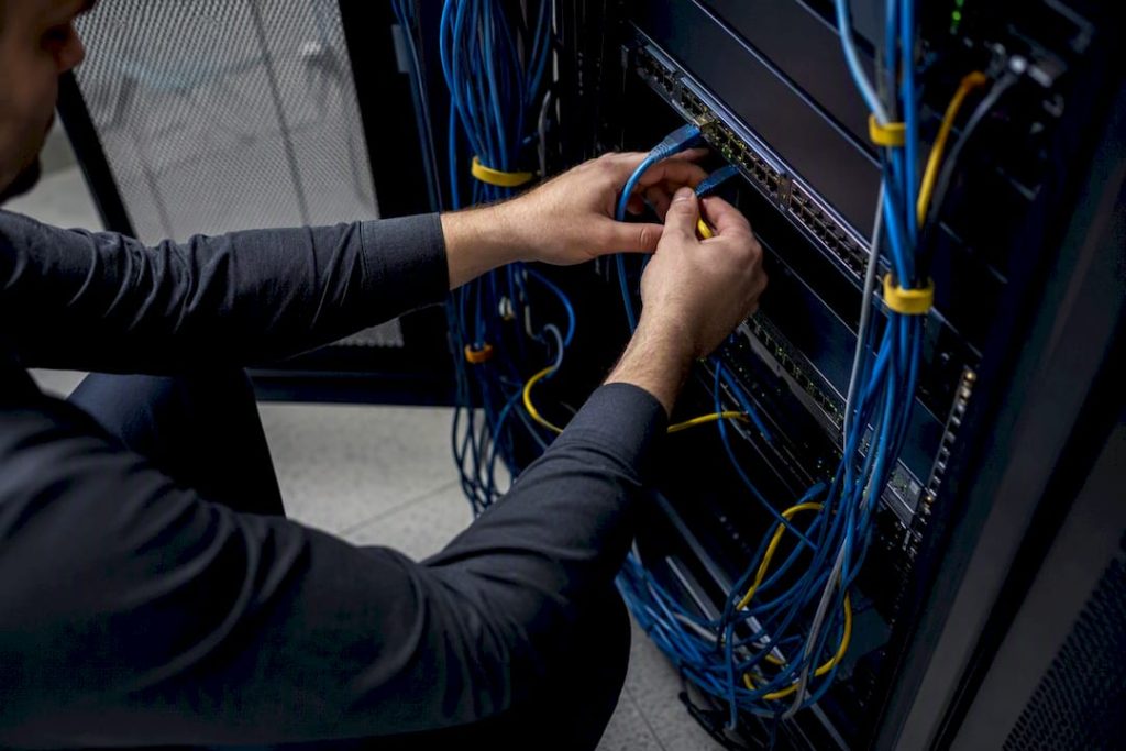 Hands connecting network cables in server room