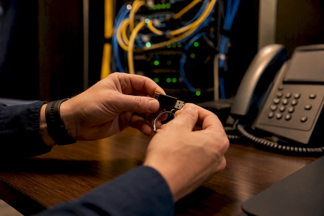 Hands clipping USB token on lanyard