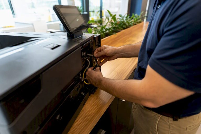 Technician adjusting printer cables