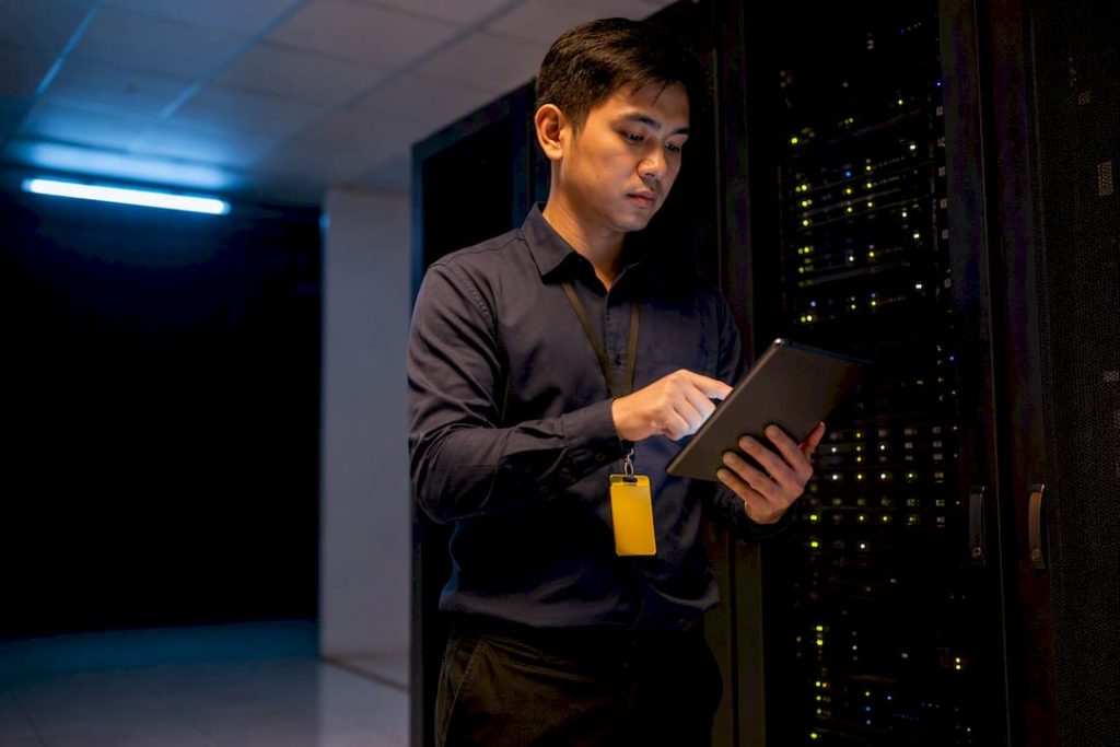 Technician auditing patch status in server room